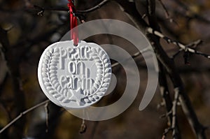 White Peace on Earth Christmas Ornament Hanging in the Winter Woods