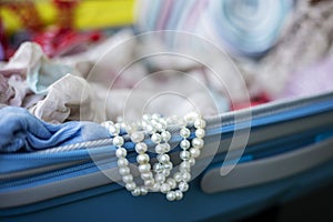 White pearl beads look out of suitcase