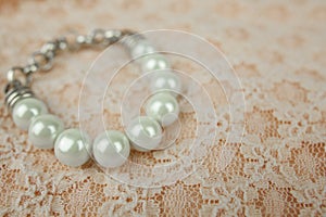 White Pearl Bracelet on Vintage Peach Lace Pattern