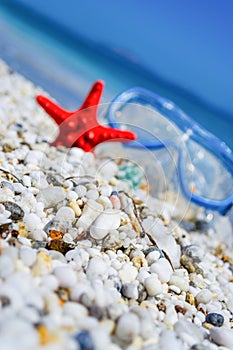 White pebbles with diving mask and sea star on the background
