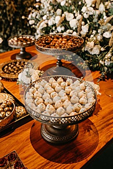 White pecan butterball cookies on a wooden table at a wedding party, vertical shot