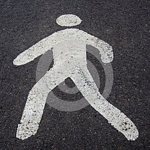 A white pedestrian sign on the road