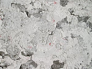 White peeling paint on a concrete wall.