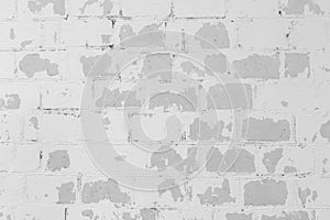 White peeling paint from old light grey brick wall weathered outdated background texture worn obsolete