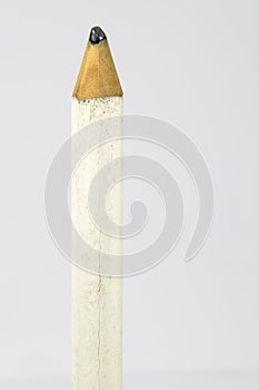 White pencil with sharp tip.