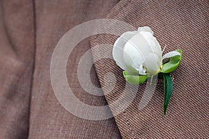 White peony bud set in oldfashioned coat lapel buttonhole
