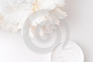 White peony and mockup face and body cream on white background. Cosmetics concept.