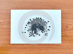 White pepper. Piper nigrum specially processed spice sample on paper wooden background.