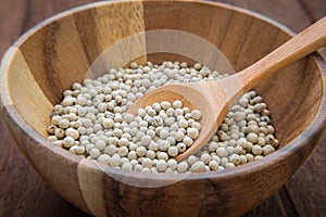 White pepper in wooden bowl