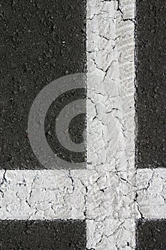 White perpendicular shaped cross on black asphalt