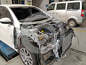 A white Peugeot 408 was parked in the workshop waiting for repair after a serious accident