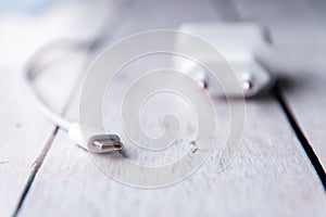 White phone charger on a wooden white background