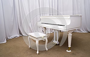 White Piano on the stage of concert hall