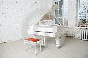 White piano in white room with brick wall