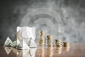 White piggy bank and coin on wood