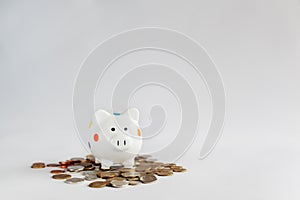 White piggy bank or money box with money coins.