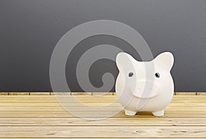 White piggy bank on wooden background with money saving concept