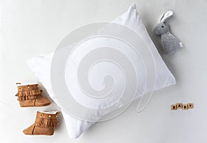 White Pillow With Baby Shoes and Toy Props Mockup - Styled Stock Photography
