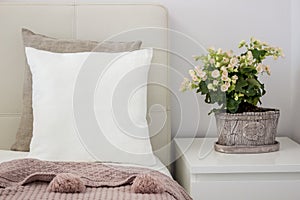 White pillow on bed in a cozy bedroom, Mockup