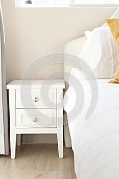 White pillow on bed with side table photo