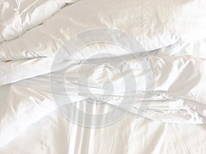 White pillow on bed and with wrinkle messy blanket in bedroom