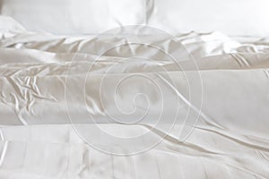 White pillow with messy messy blanket on bed in bedroom Close up