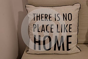 White pillow with `There is no place like home` message written on it