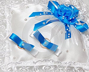 White pillow for wedding rings blue ribbons