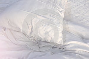White pillow with wrinkle messy blanket on bed in bedroom