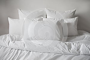 White pillows, duvet and duvetcase in a bed. Side view