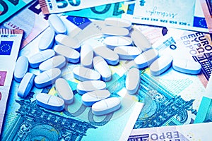 White pills on the background of euro bills. The concept of the expensive cost of healthcare