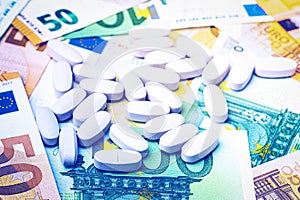 White pills on the background of euro bills. The concept of the expensive cost of healthcare
