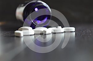 White pills on black background