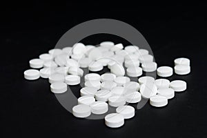 White pills in the black background
