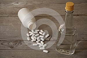 White pills with bottle and bottle of medicine alcohol