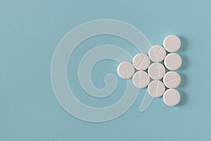 White pills on the bright blue surface.