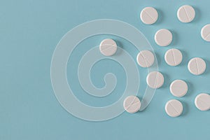 White pills on the bright blue surface.