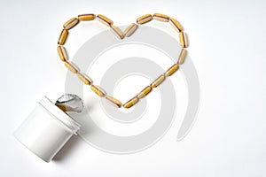 White pills are in the form of a heart sign and bittle on a white background. Medicine concept for bussiness