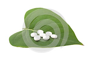 White pills on green leaf
