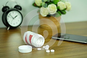 White pills and medicine bottles, paracetamol on the desk wooden table, Headache medicine Vitamin And Dietary Supplements