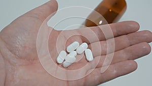 White pills in palm of hand. Medicine for pain relief.