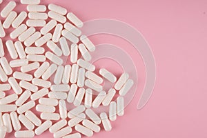 White pills on pastel coloured background. Medication and prescription pills flat lay background.