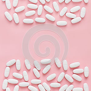 White pills on pink background. Medical concept pattern