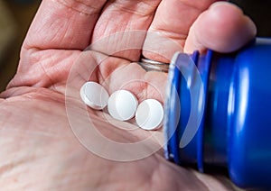 White pills poured from a bottle