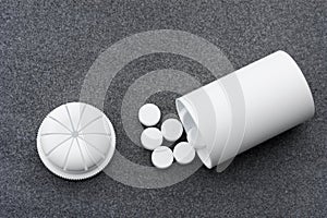 White Pills Scattered On A Gray Background And An Open Bottle