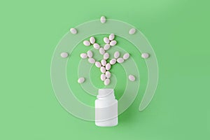 White pills in shape of tree on green background. Natural medical pharmacy concept. Probiotics benefits.