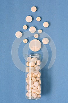 White pills spilling out of pill bottle