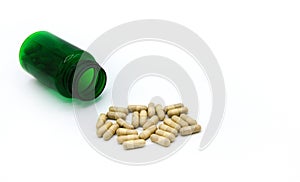 White pills spilling or pour out of green pill bottle isolated on white background with copy space for add text.