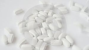 white pills tablets falling down on bright pure surface