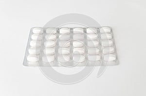 White pills tablets in package on a white background. Capsule pills in plastic pack for pharmacy and medicine